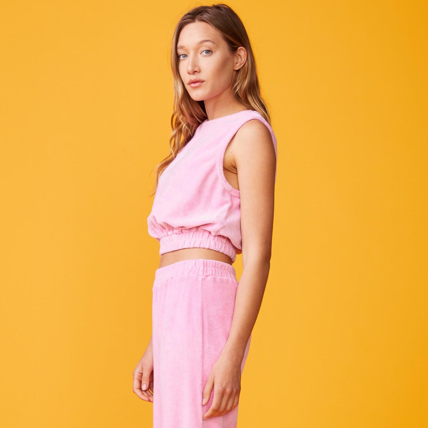 Side view of model wearing the terry cloth tank in bubble gum.
