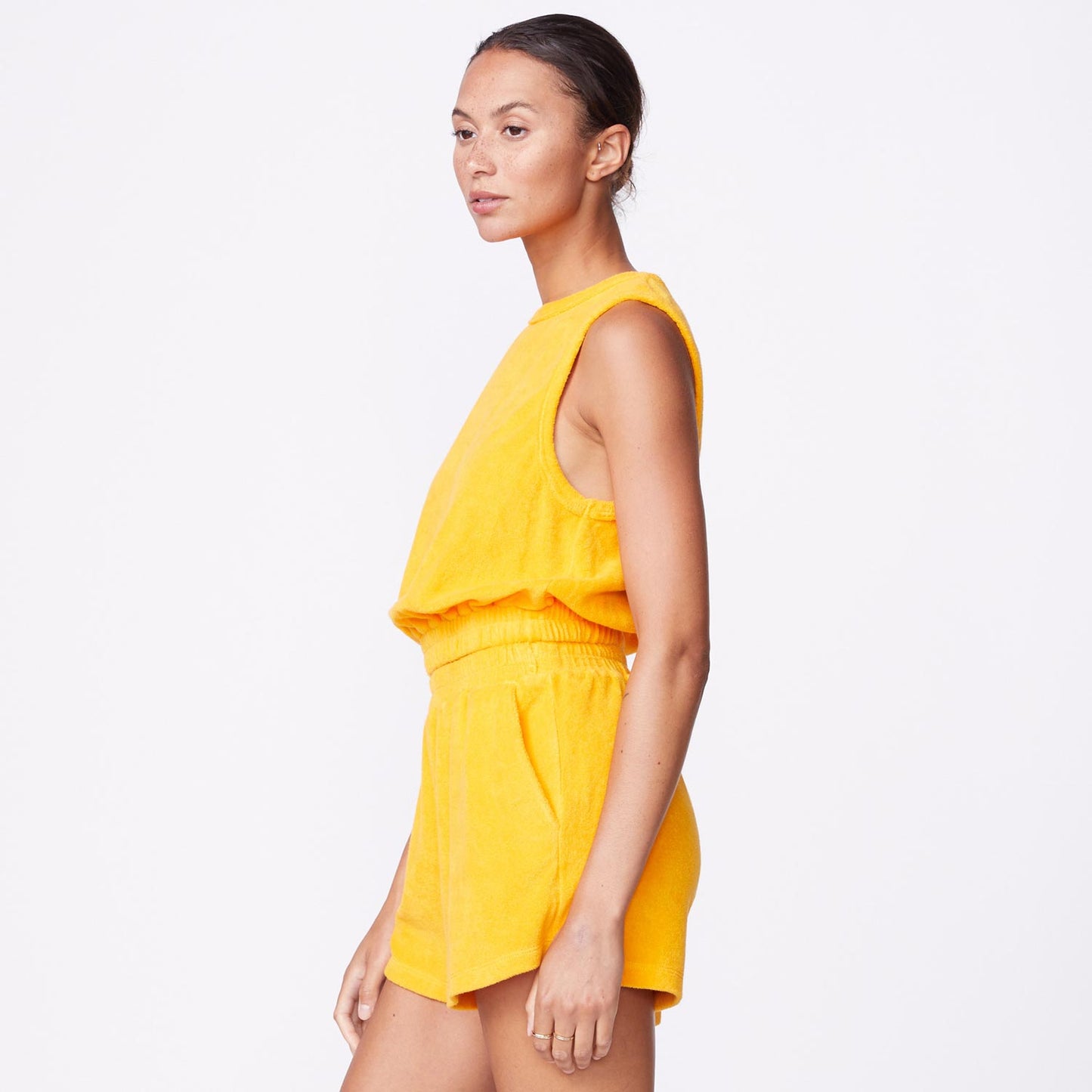 Side view of model wearing the terry cloth tank in marigold.