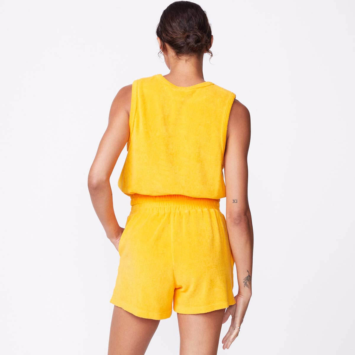 Back view of model wearing the terry cloth tank in marigold.