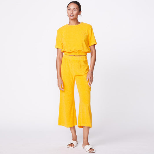 Front view of model wearing the terry cloth tee in marigold.