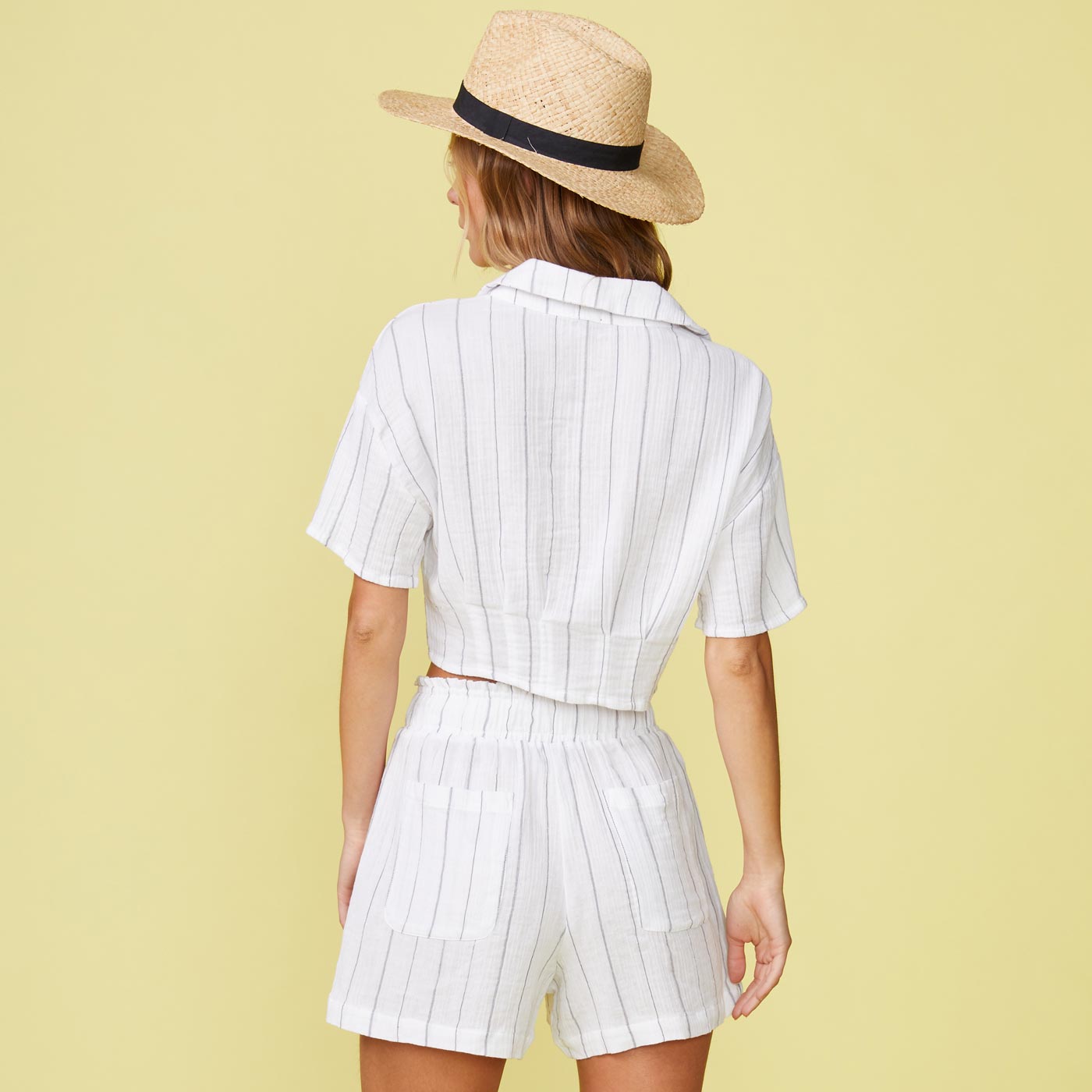 Back view of model wearing the pinstripe gauze cropped short sleeve in white.