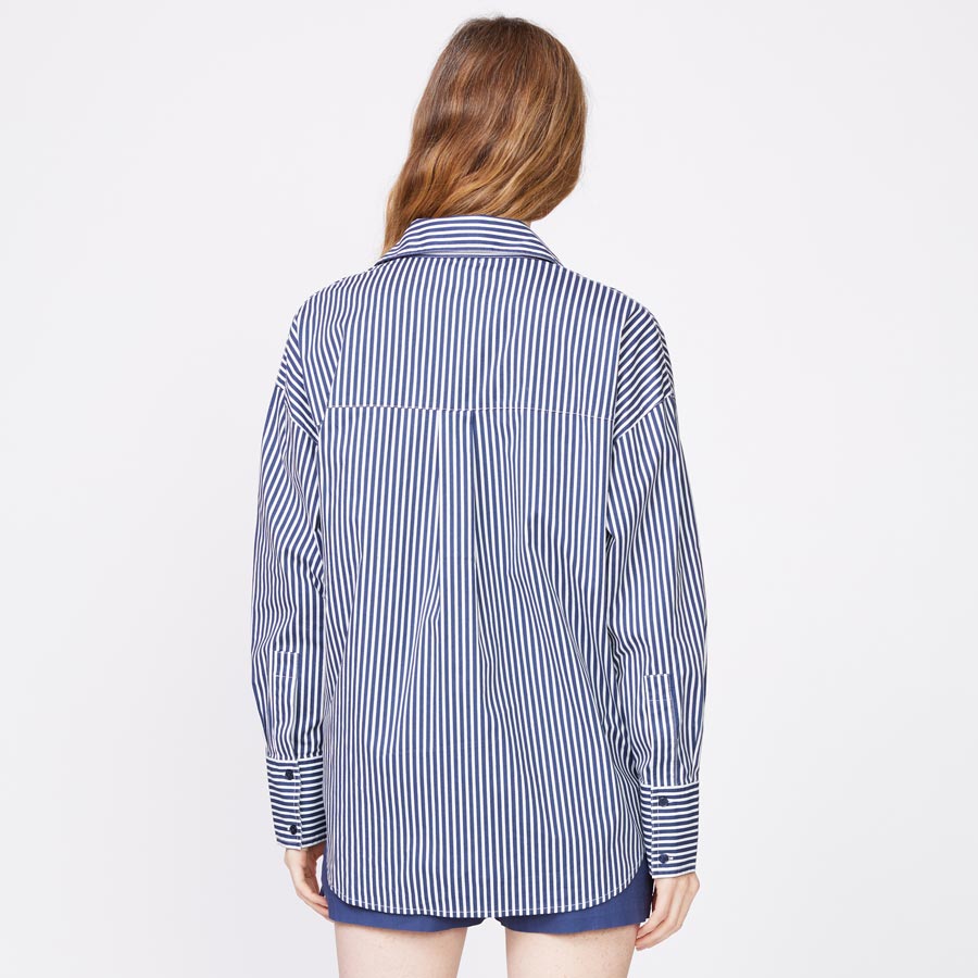 Back view of model wearing the stretch poplin stripe shirt in french navy.