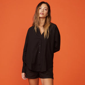 Front view of model wearing the poplin shirt in black.