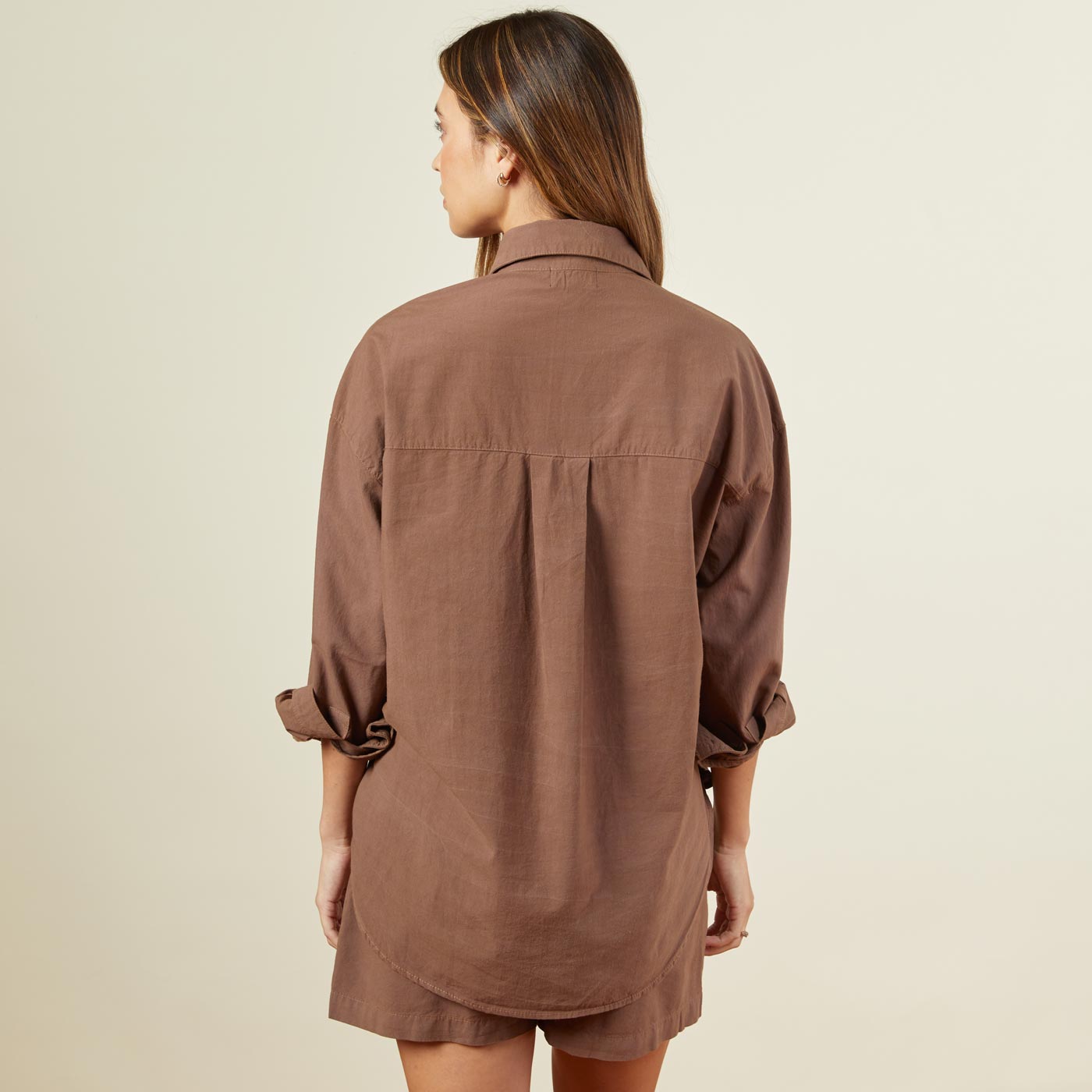 Back view of model wearing the poplin shirt in dusty cocoa.