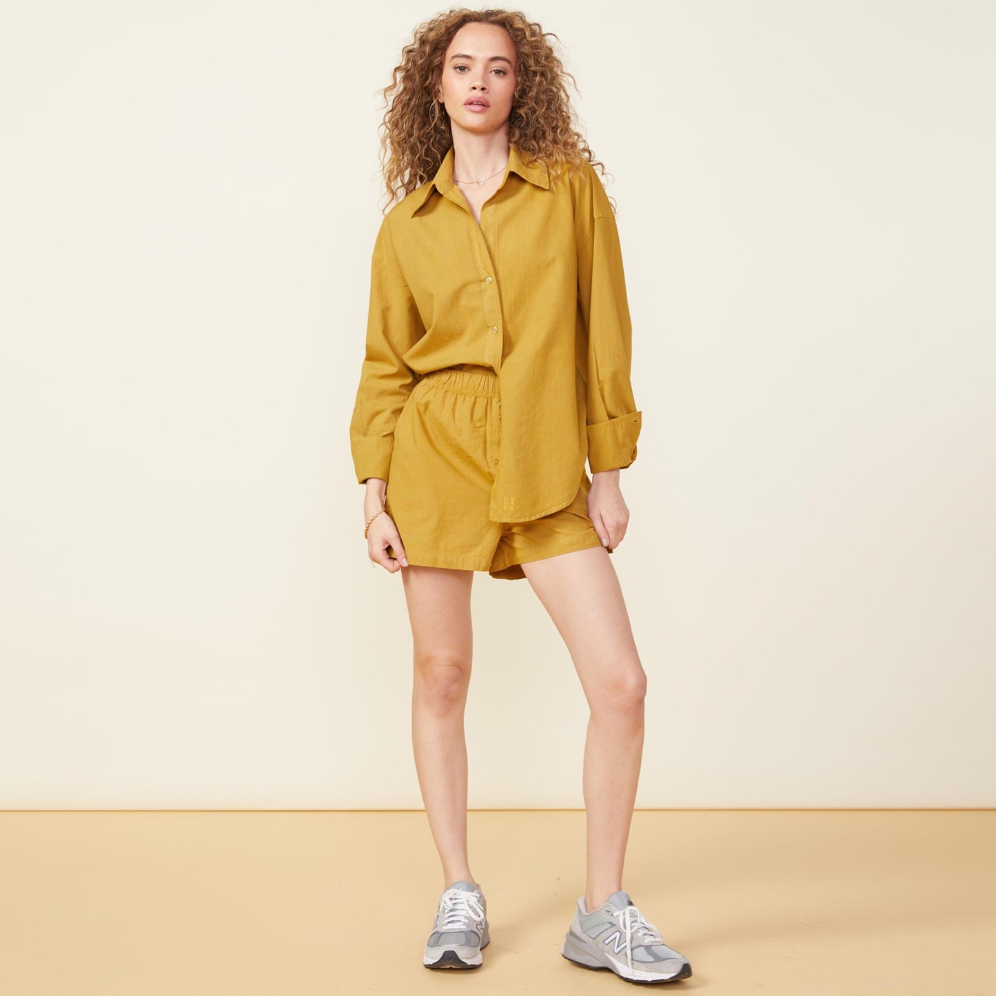 Front view of model wearing the poplin shirt in golden olive.