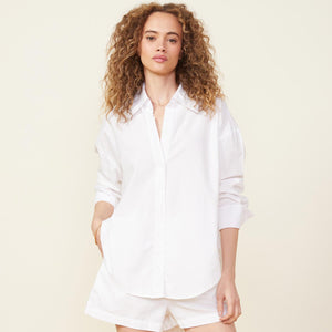 Front view of model wearing the poplin shirt in white.