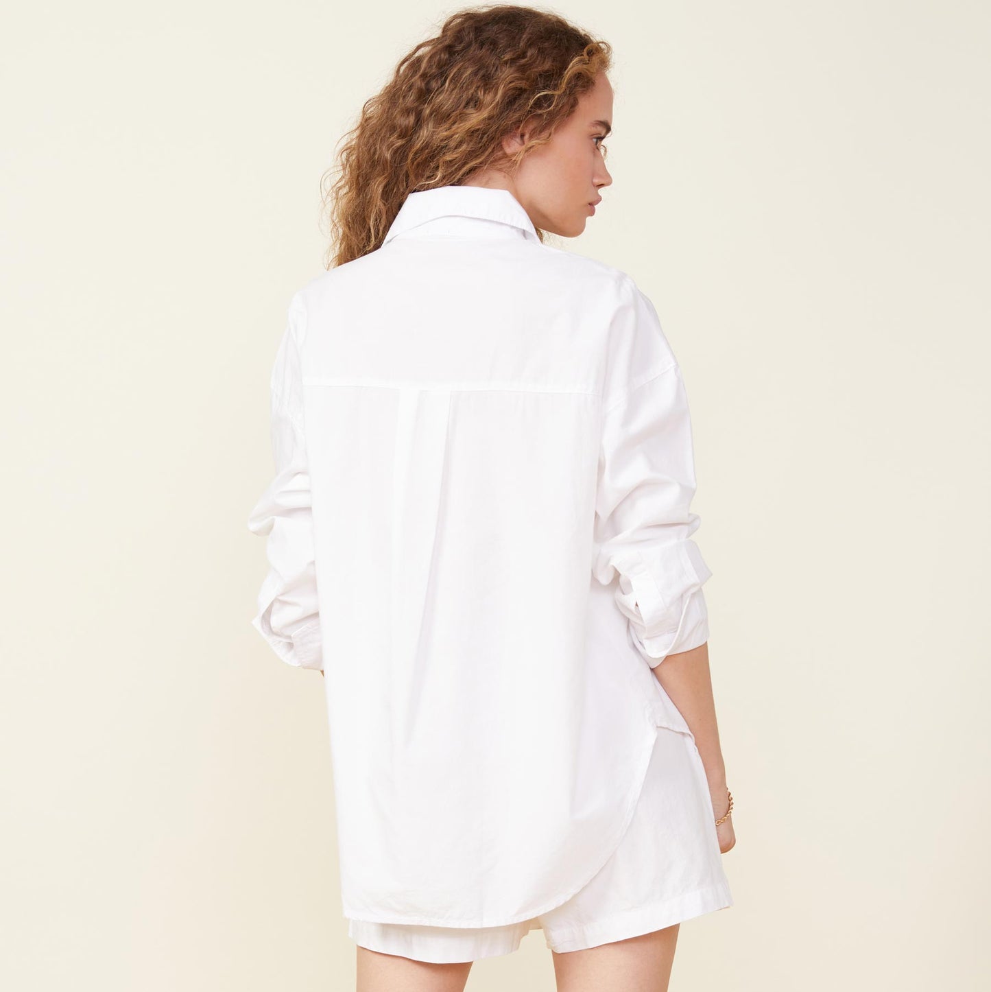 Back view of model wearing the poplin shirt in white.