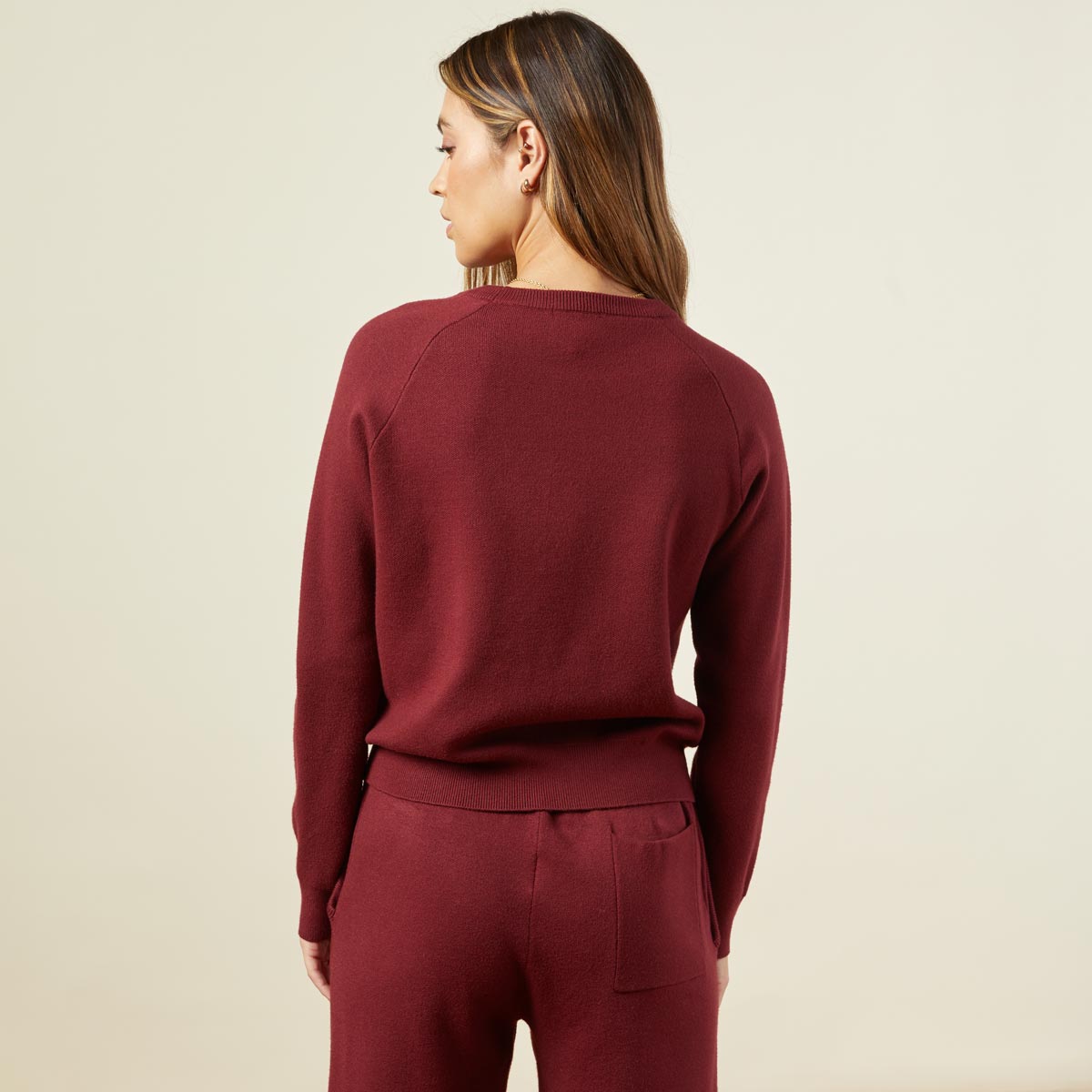 Back view of model wearing the supersoft sweater knit raglan in rhubarb.