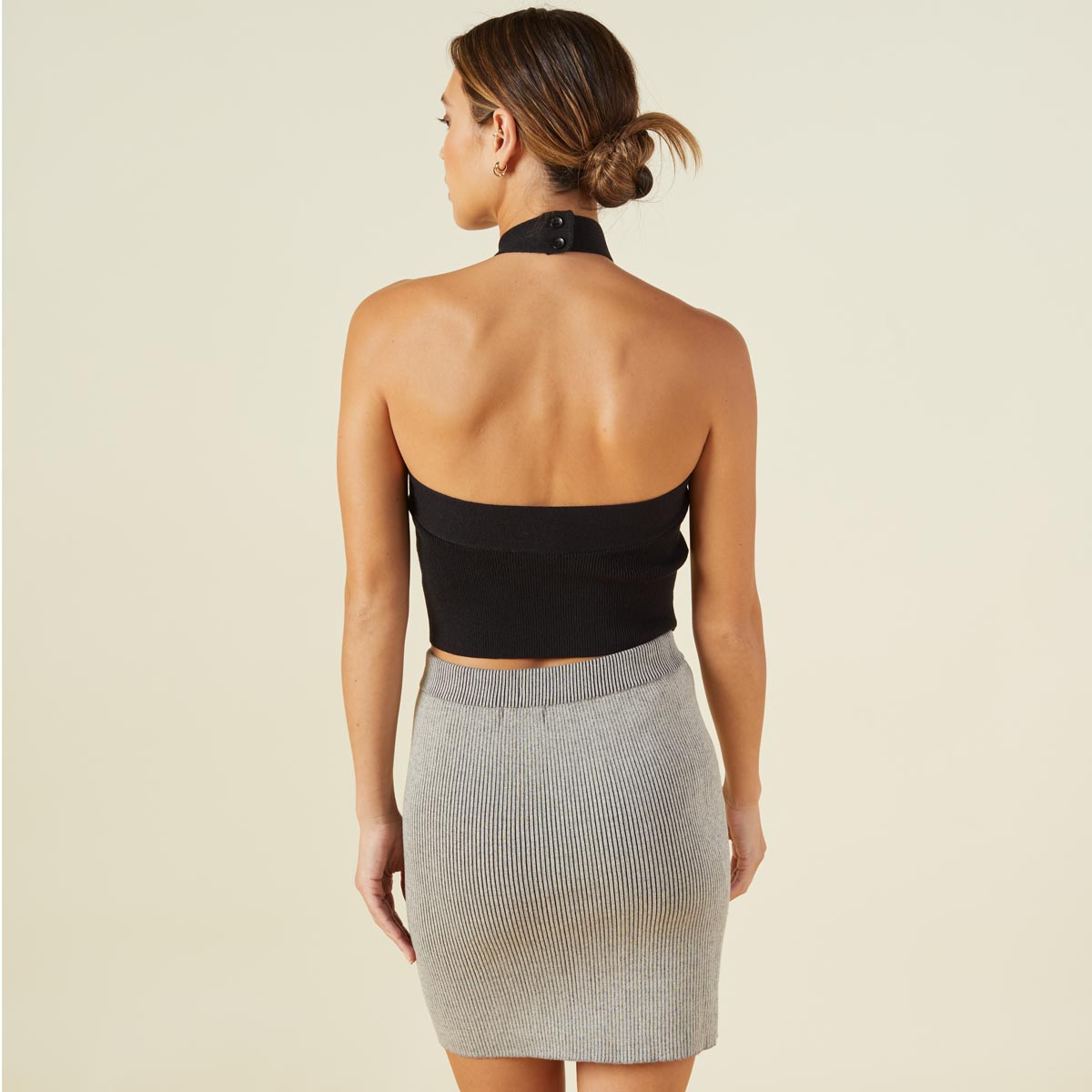 Back view of model wearing the supersoft sweater knit halter in black.