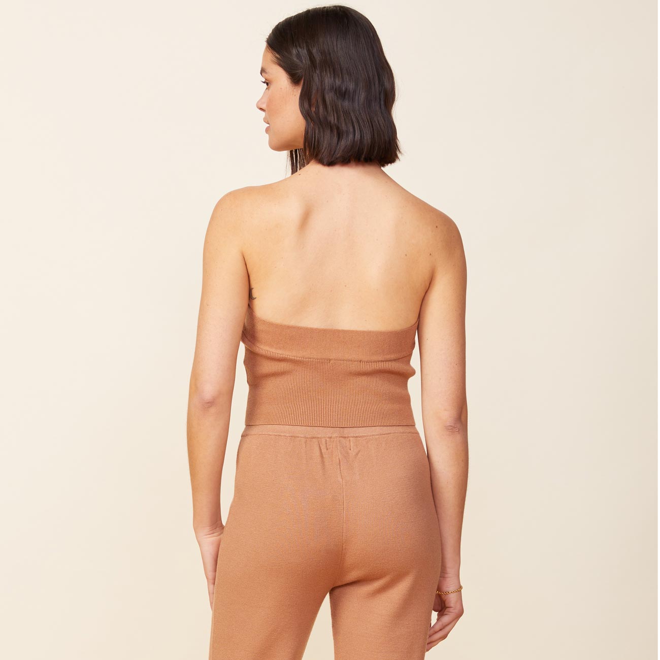 Back view of model wearing the supersoft sweater knit halter in doe.