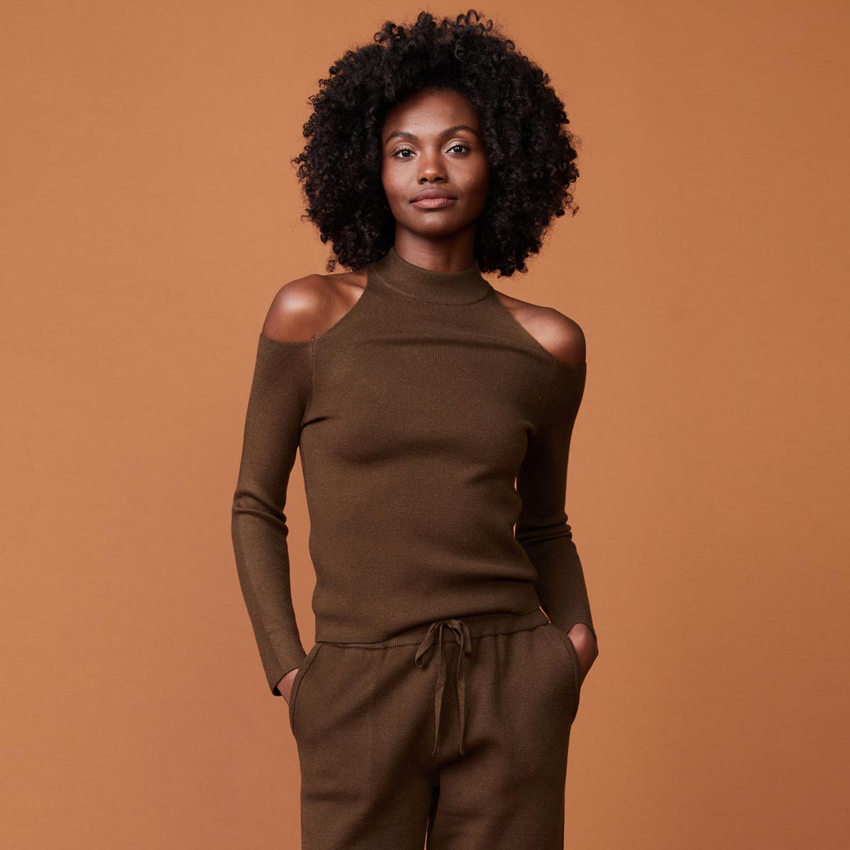 Front view of model wearing the supersoft sweater knit cold shoulder top in moss.