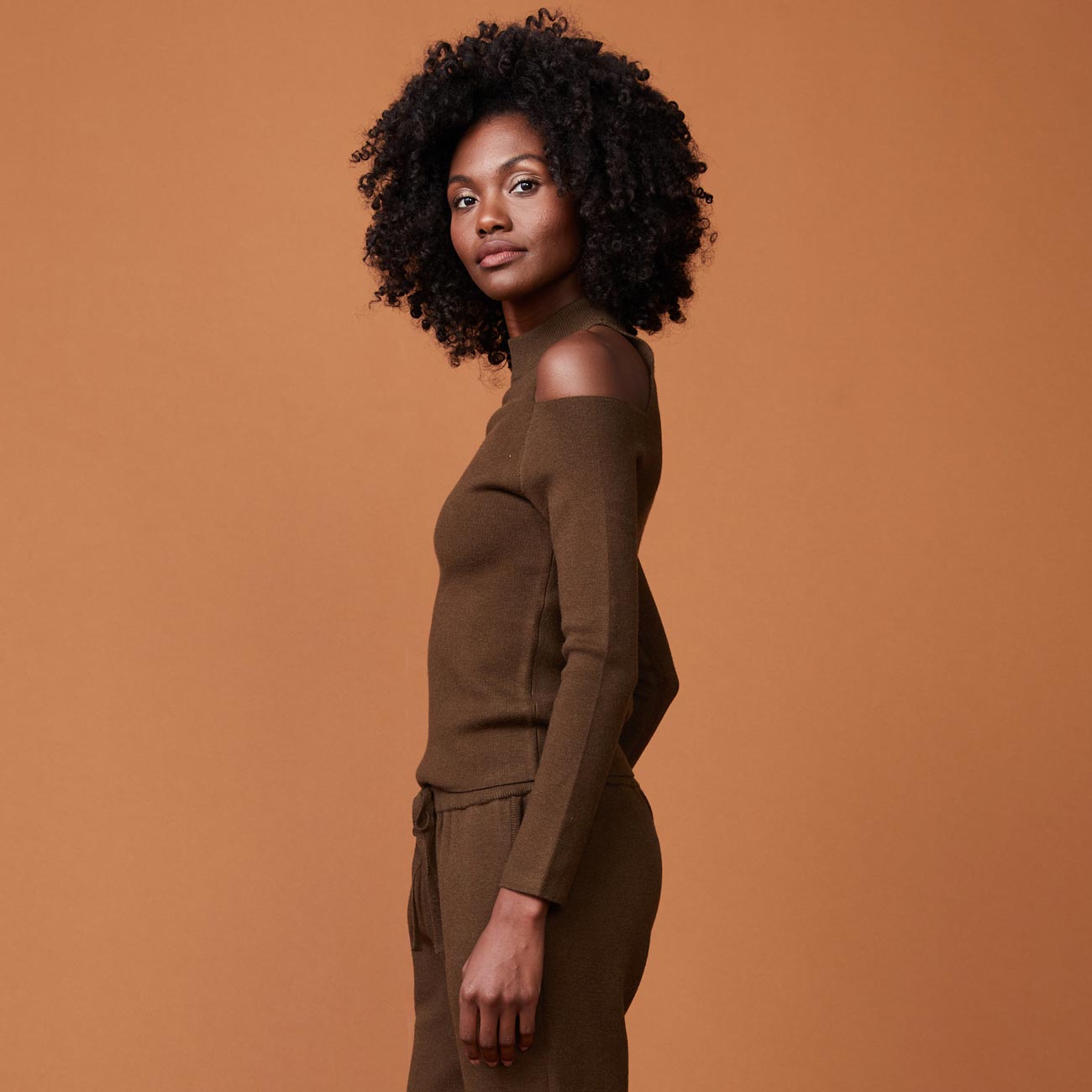 Side view of model wearing the supersoft sweater knit cold shoulder top in moss.