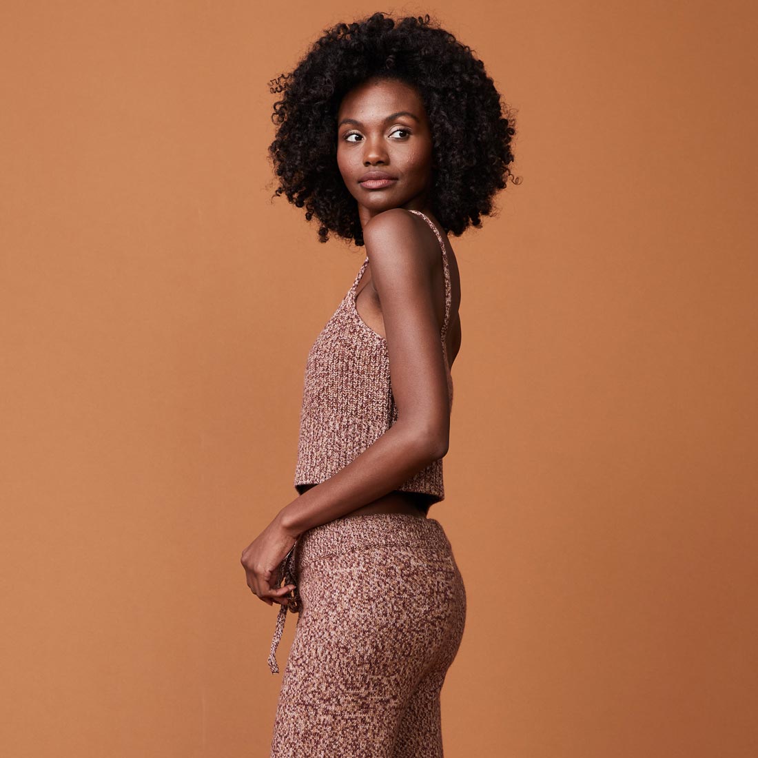 Side view of model wearing the marled tank in pomegranate.