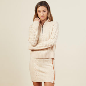 Front view of model wearing the merino cable knit half zip in off white.