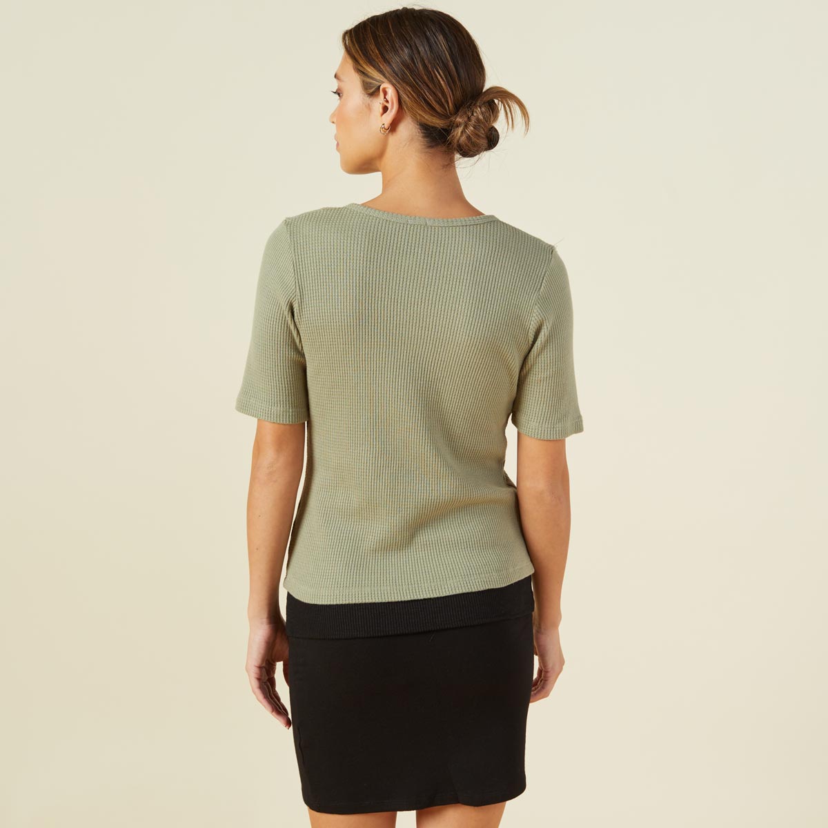 Back view of model wearing the thermal short sleeve henley in laurel green.