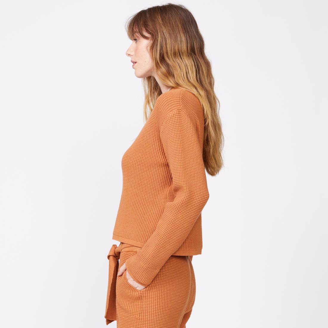 Side view of model wearing the supersoft sweater knit henley top in nugget.