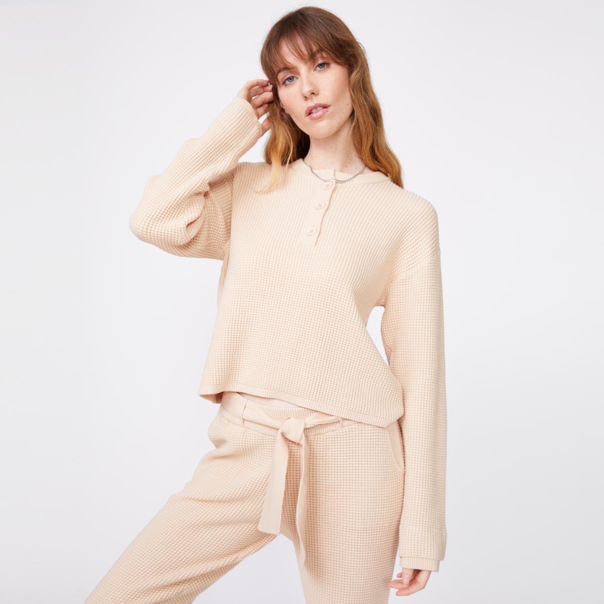 Front view of model wearing the supersoft sweater knit henley top in off white.