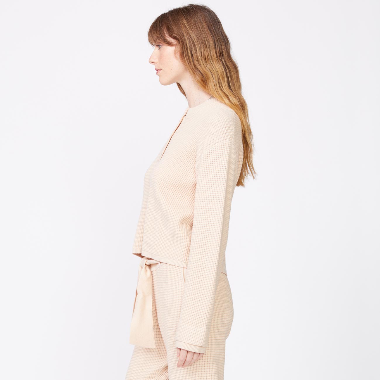 Side view of model wearing the supersoft sweater knit henley top in off white.