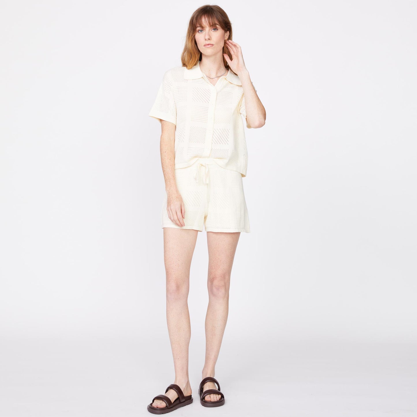Front view of model wearing the crochet knit vacation shirt in off white.