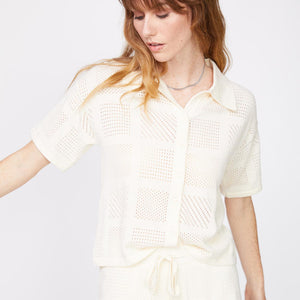 Front view of model wearing the crochet knit vacation shirt in off white.