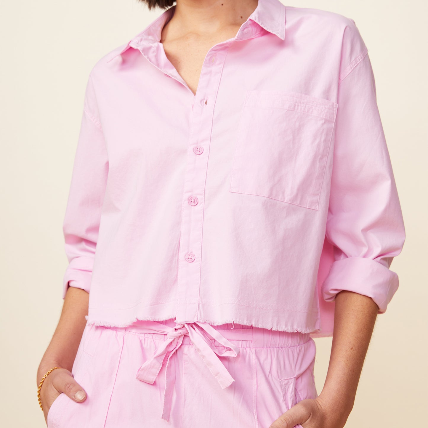 Front view of model wearing the cropped poplin shirt in pink lavender.