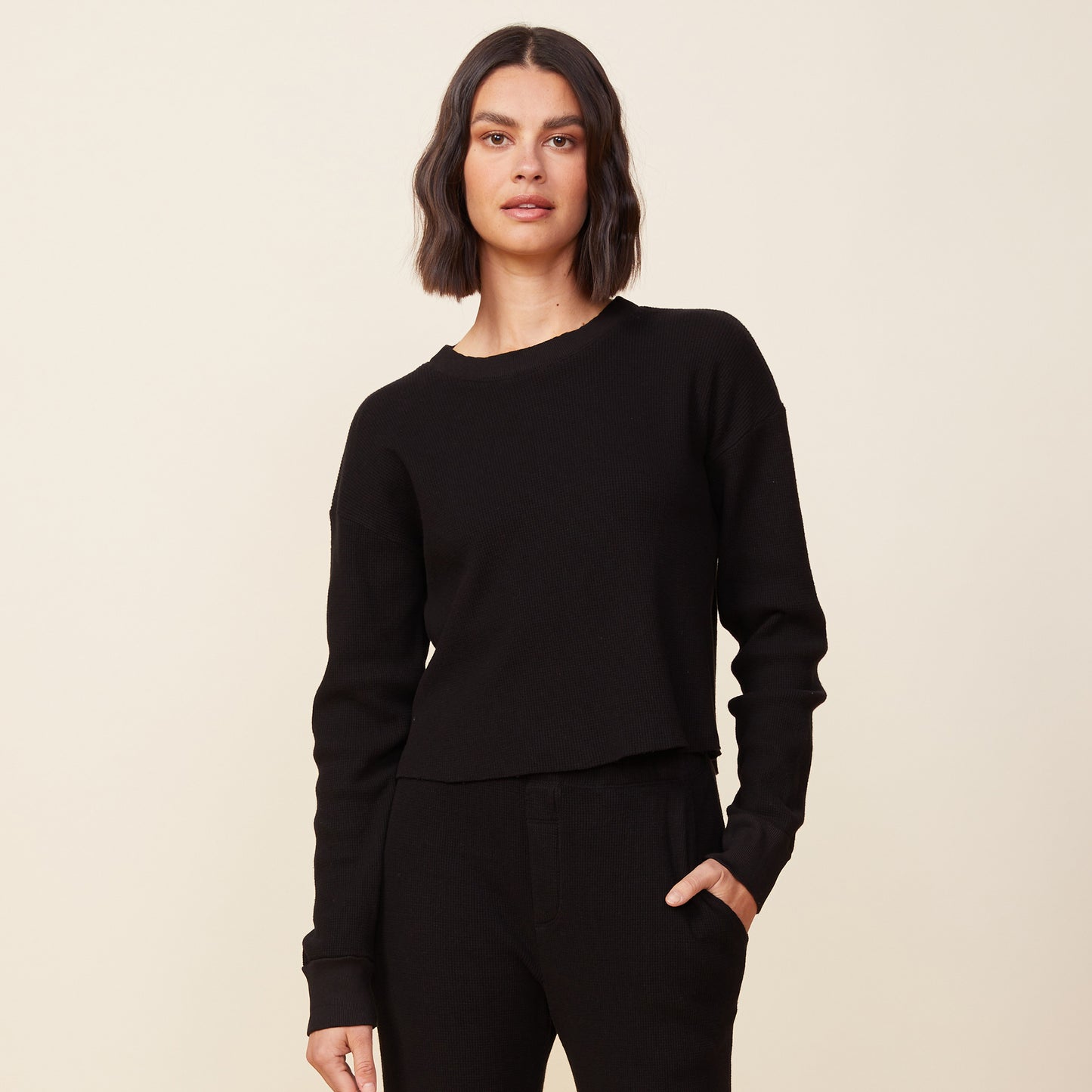 Front view of model wearing the thermal top in black.