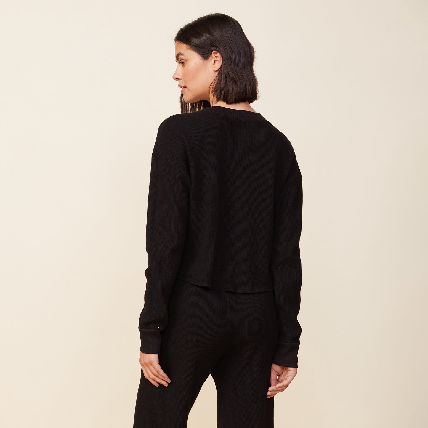 Back view of model wearing the thermal top in black.