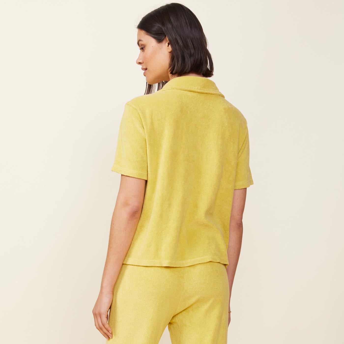 Back view of model wearing the terry cloth pocket shirt in kiwi.