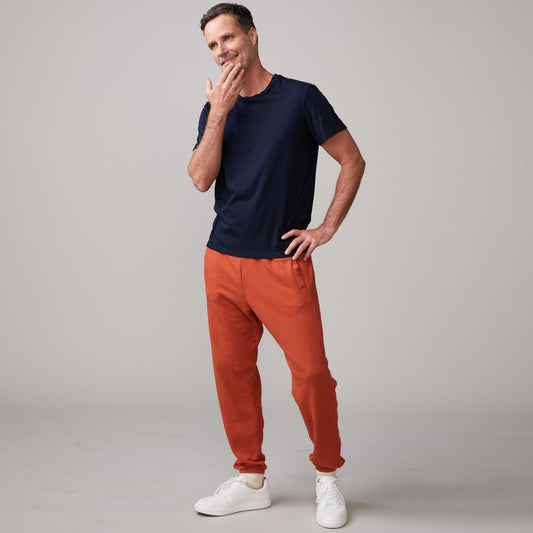 Front view of model wearing the lounge sweats in faded rust.