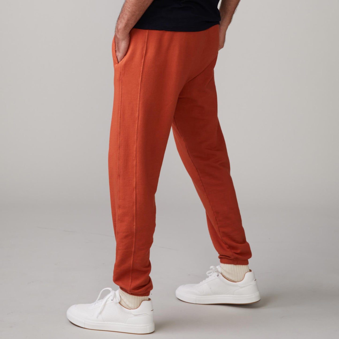 Side view of model wearing the lounge sweats in faded rust.