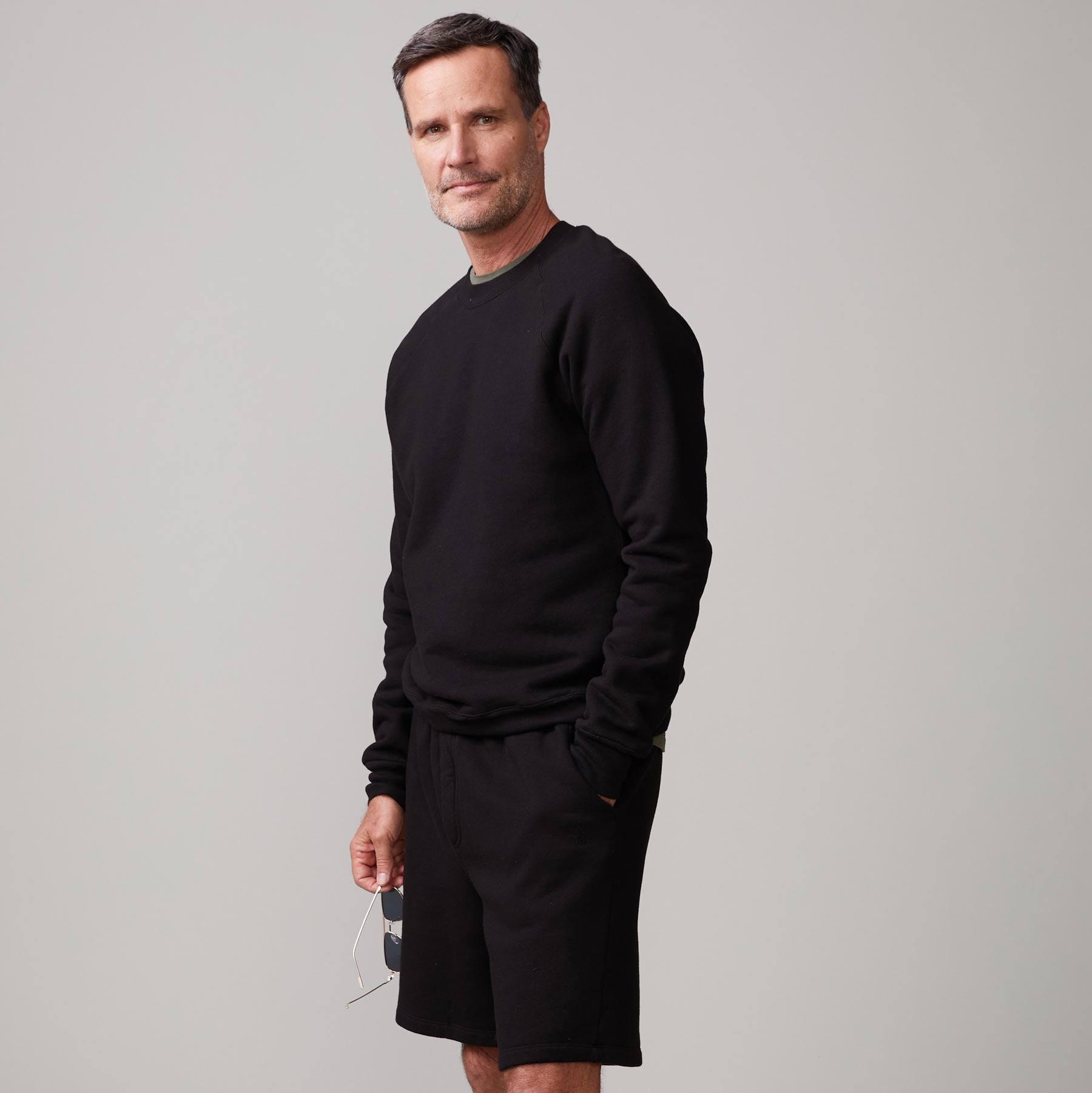 Side view of model wearing the 70's raglan in black.