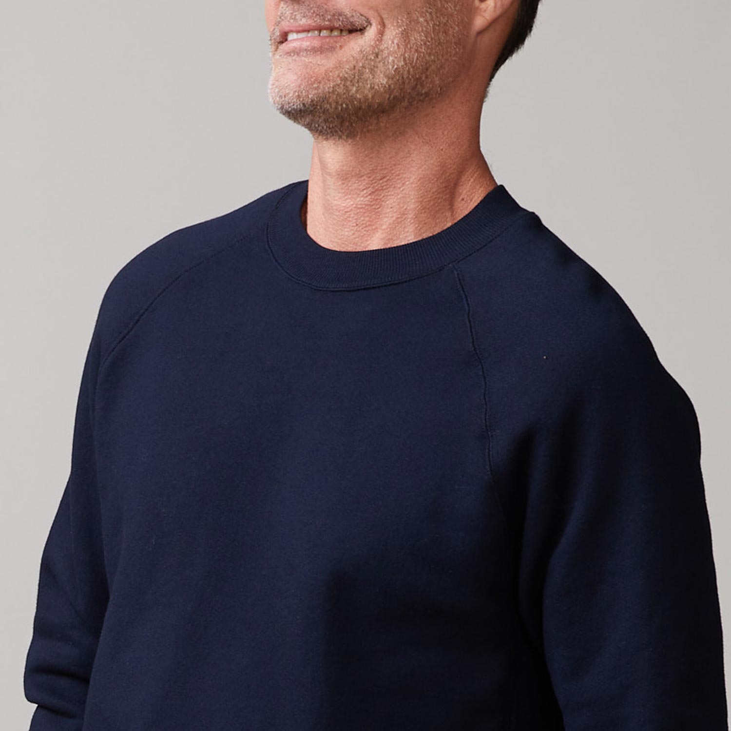 Close up view of model wearing the 70's raglan in indigo.