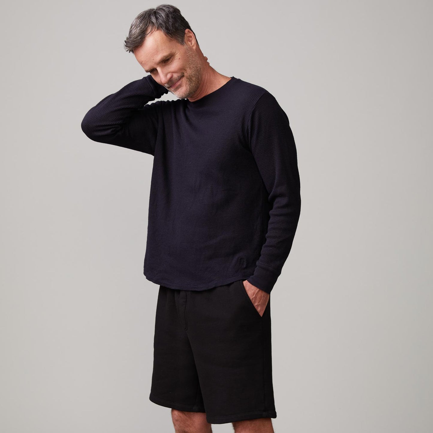 Side view of model wearing the thermal long sleeve crew in black.
