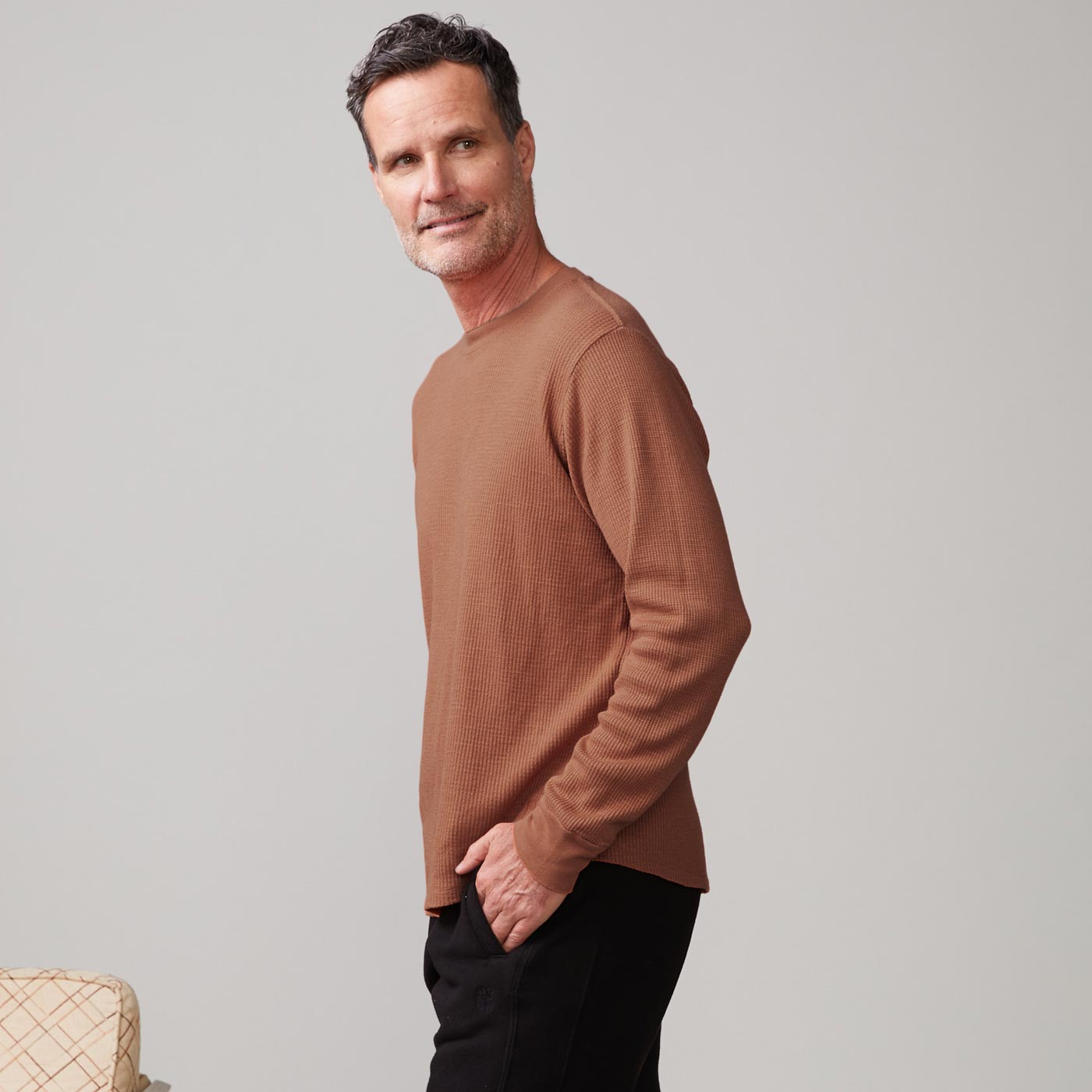 Side view of model wearing the thermal long sleeve crew in caramel.