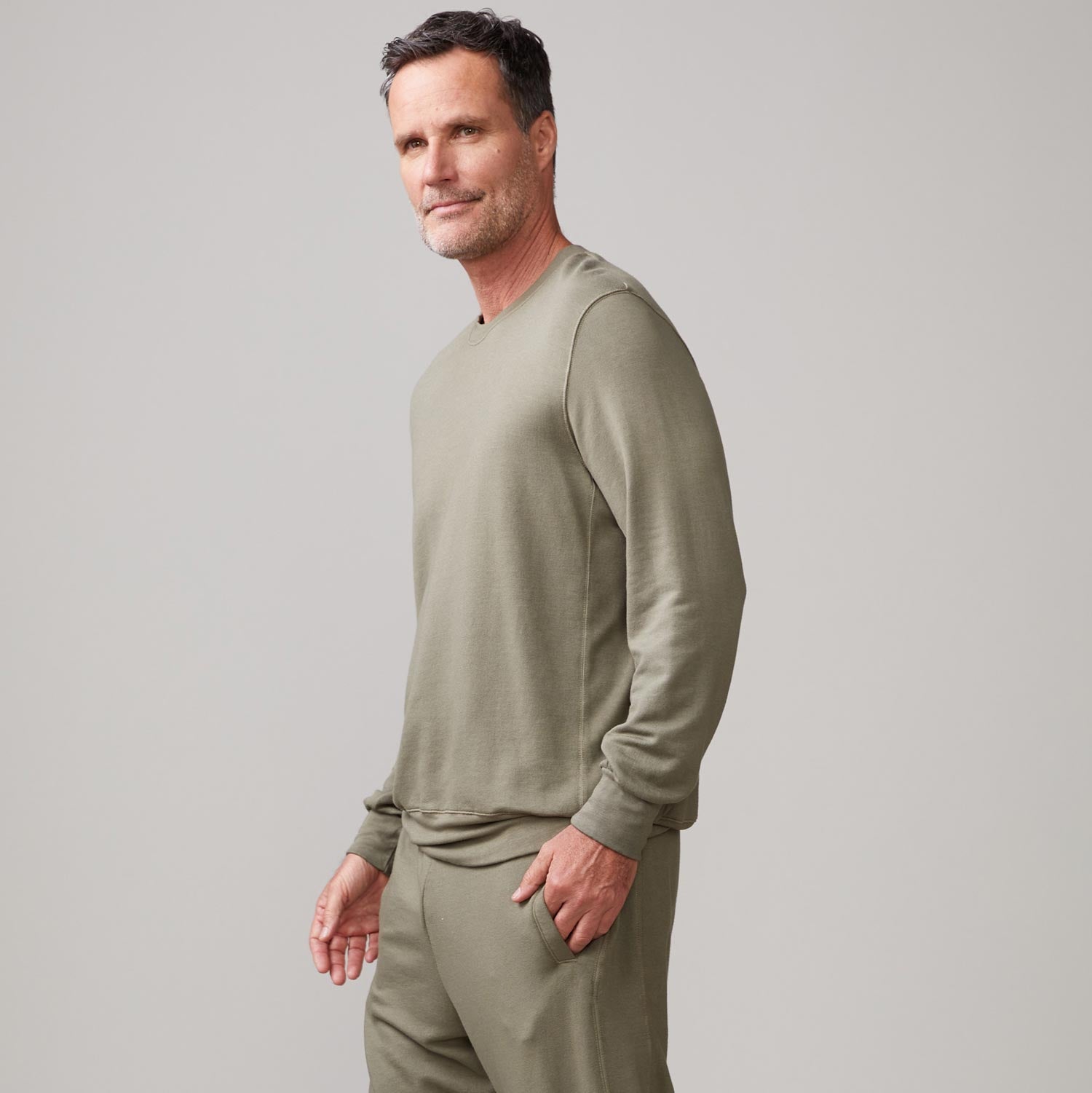 Side view of model wearing the lounge sweatshirt in army.