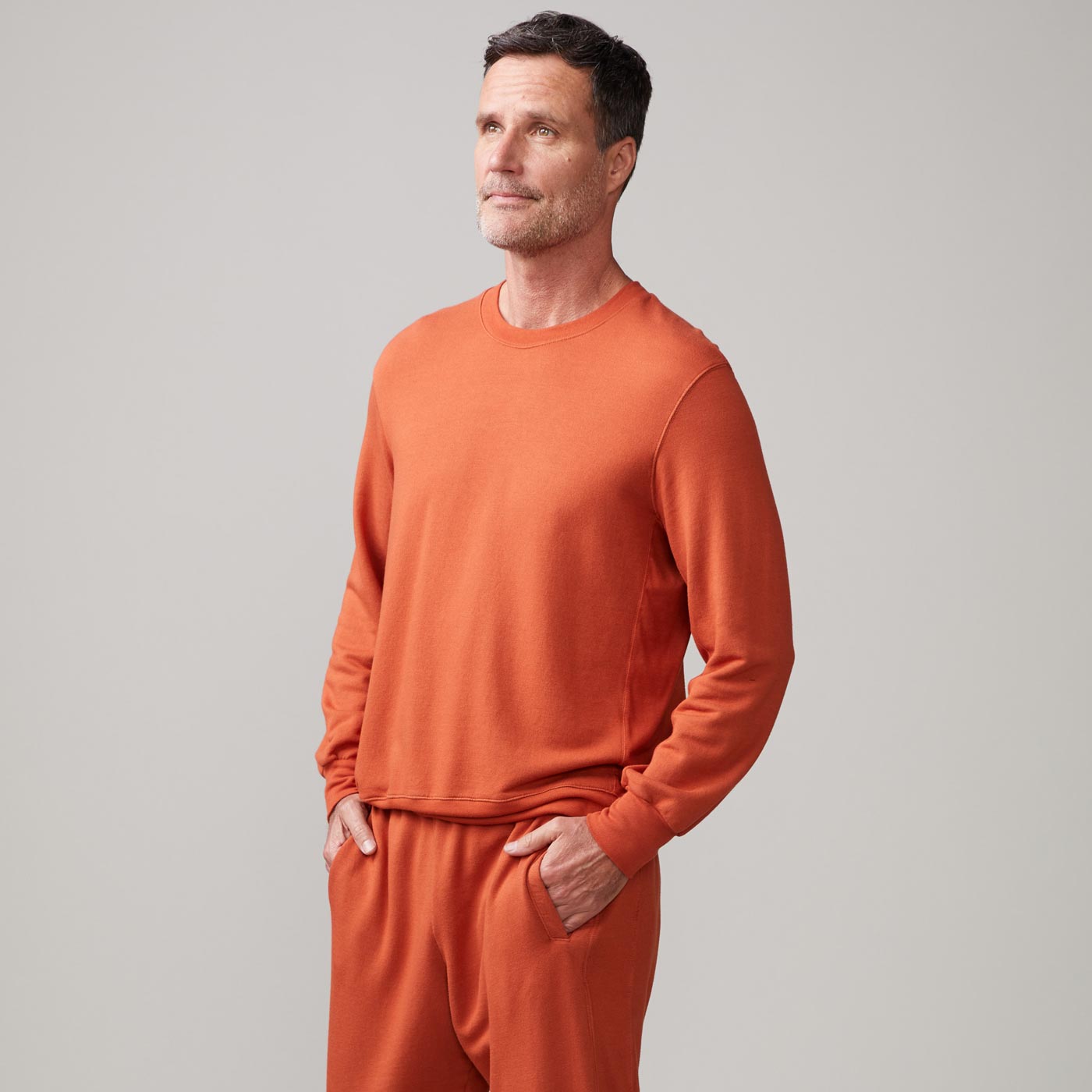 Side view of model wearing the lounge sweatshirt in faded rust.