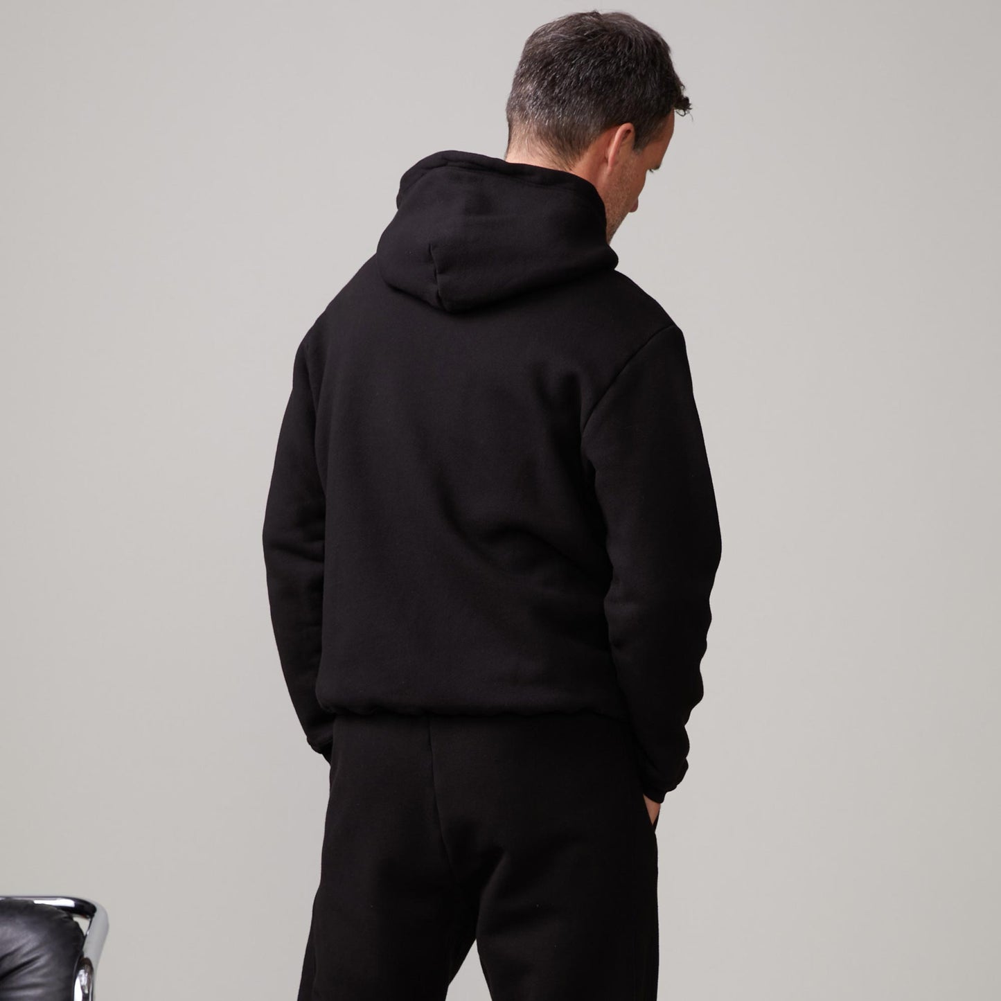 Back view of model wearing the oversized hoody in black.