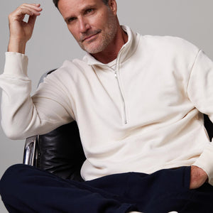 Front view of model wearing the half zip sweatshirt in off white.