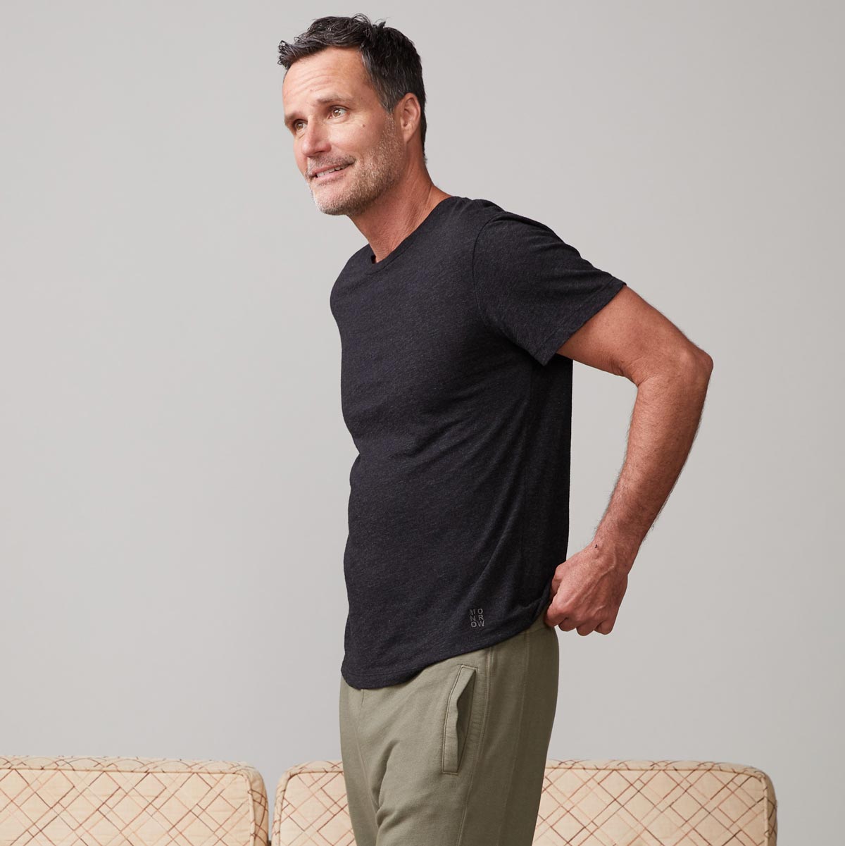 Side view of model wearing the textured tri-blend relaxed crew in black.
