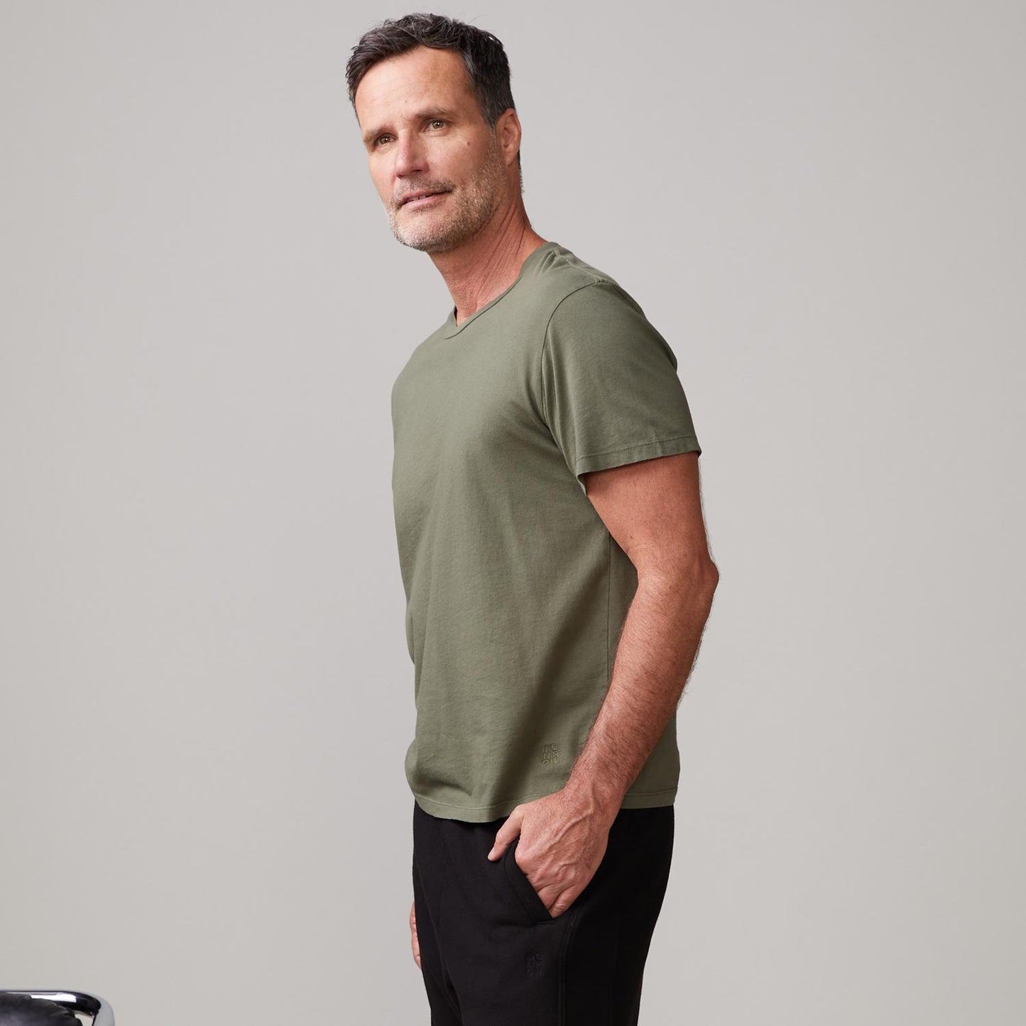 Side view of model wearing the relaxed crew in general green.