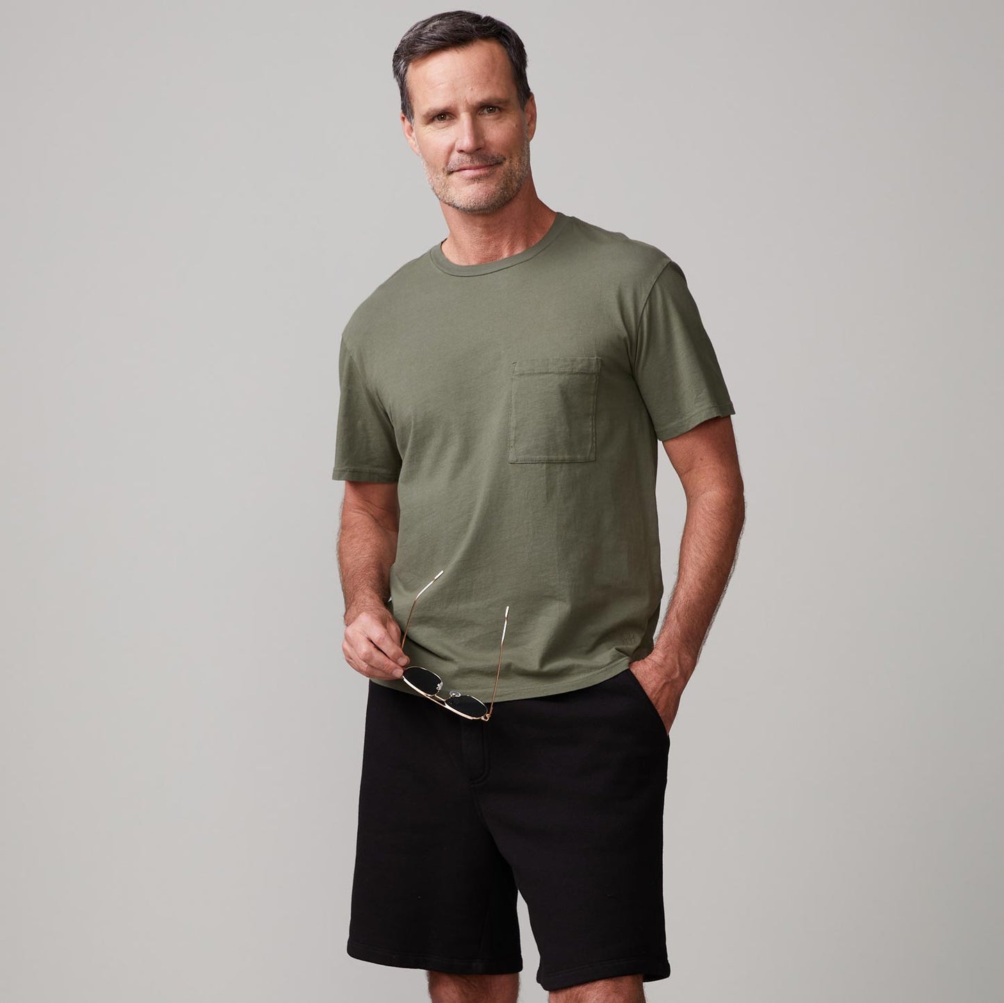 Front view of model wearing the relaxed pocket crew in general green.