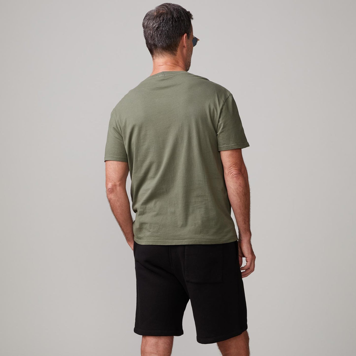 Back view of model wearing the relaxed pocket crew in general green.