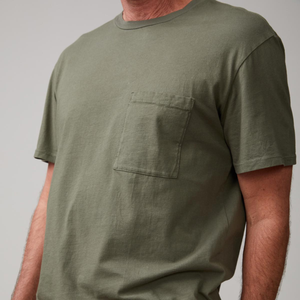 Close up of model wearing the relaxed pocket crew in general green.